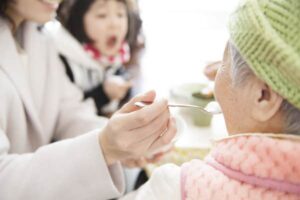 decide about LTC insurance+aide-feeding-lady